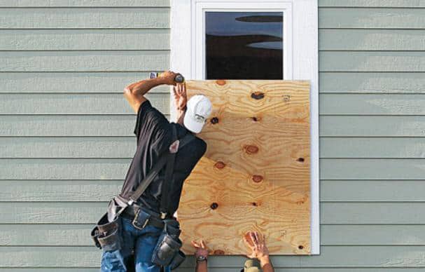 boarding up the windows, preparing for a storm